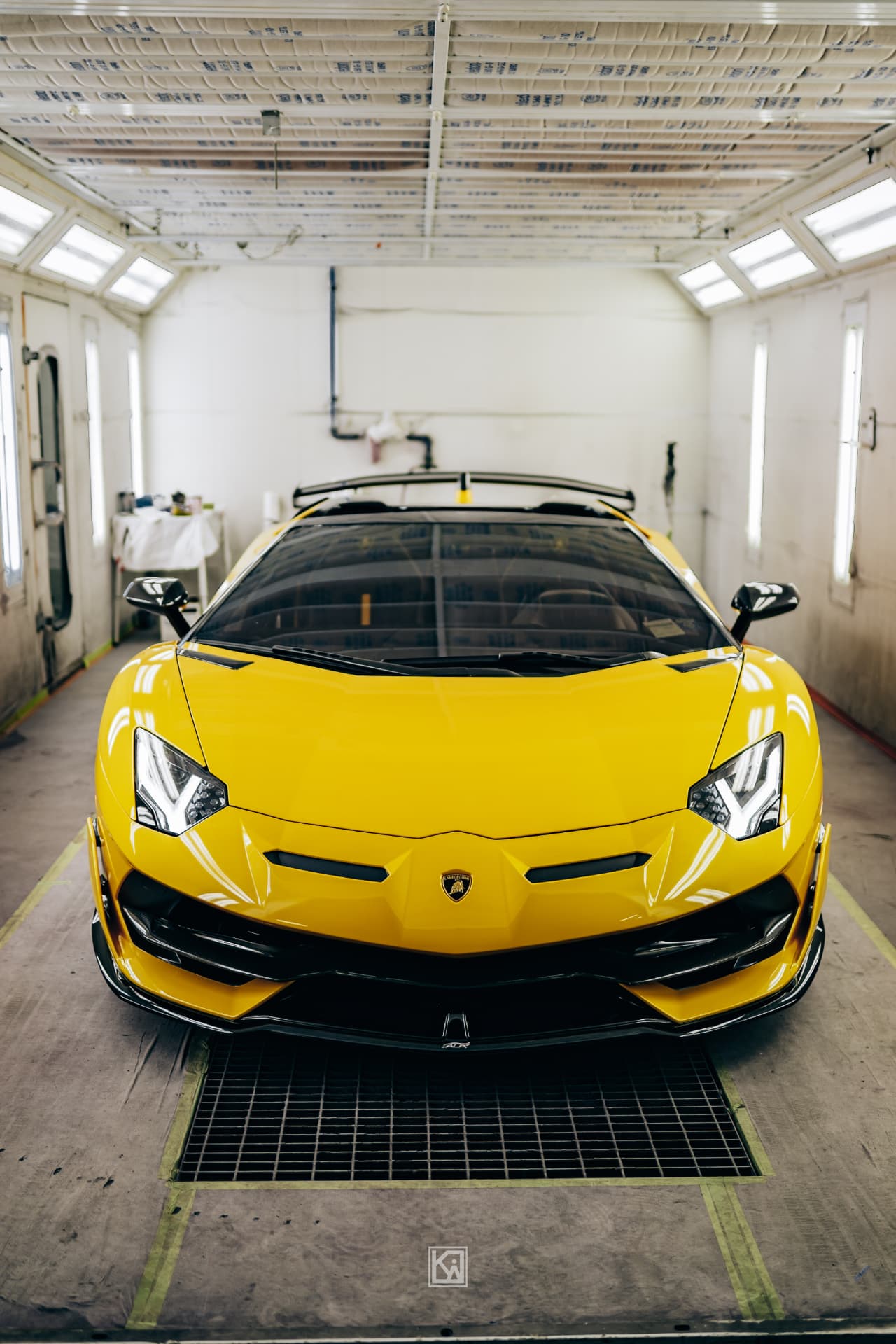 Yellow Lamborghini inside a paint booth